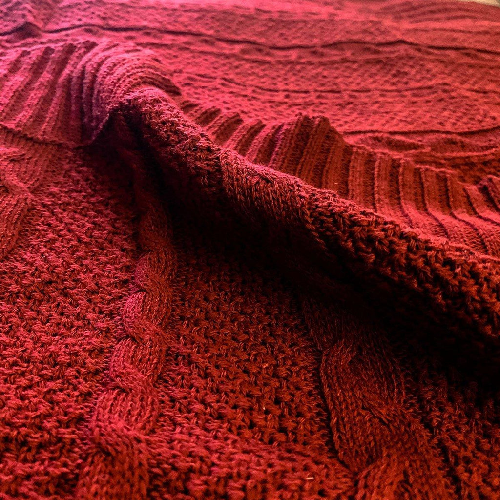 Claret Cotton-Blend Cable-Knit Throw: Close-up of textured red cable-knit fabric.