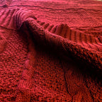 Claret Cotton-Blend Cable-Knit Throw: Close-up of textured red cable-knit fabric.
