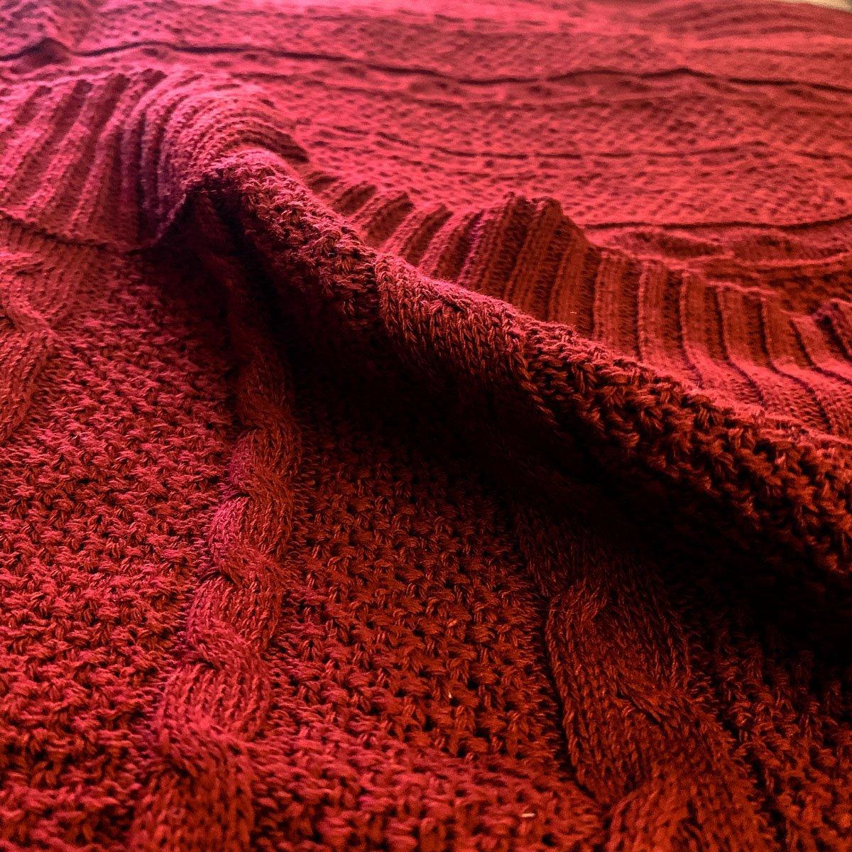 Claret Cotton-Blend Cable-Knit Throw: Close-up of textured red cable-knit fabric.