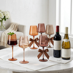 Venus Brown Wine Glasses — Set of 6: Brown wine glasses beside wine and flowers on a dining table.