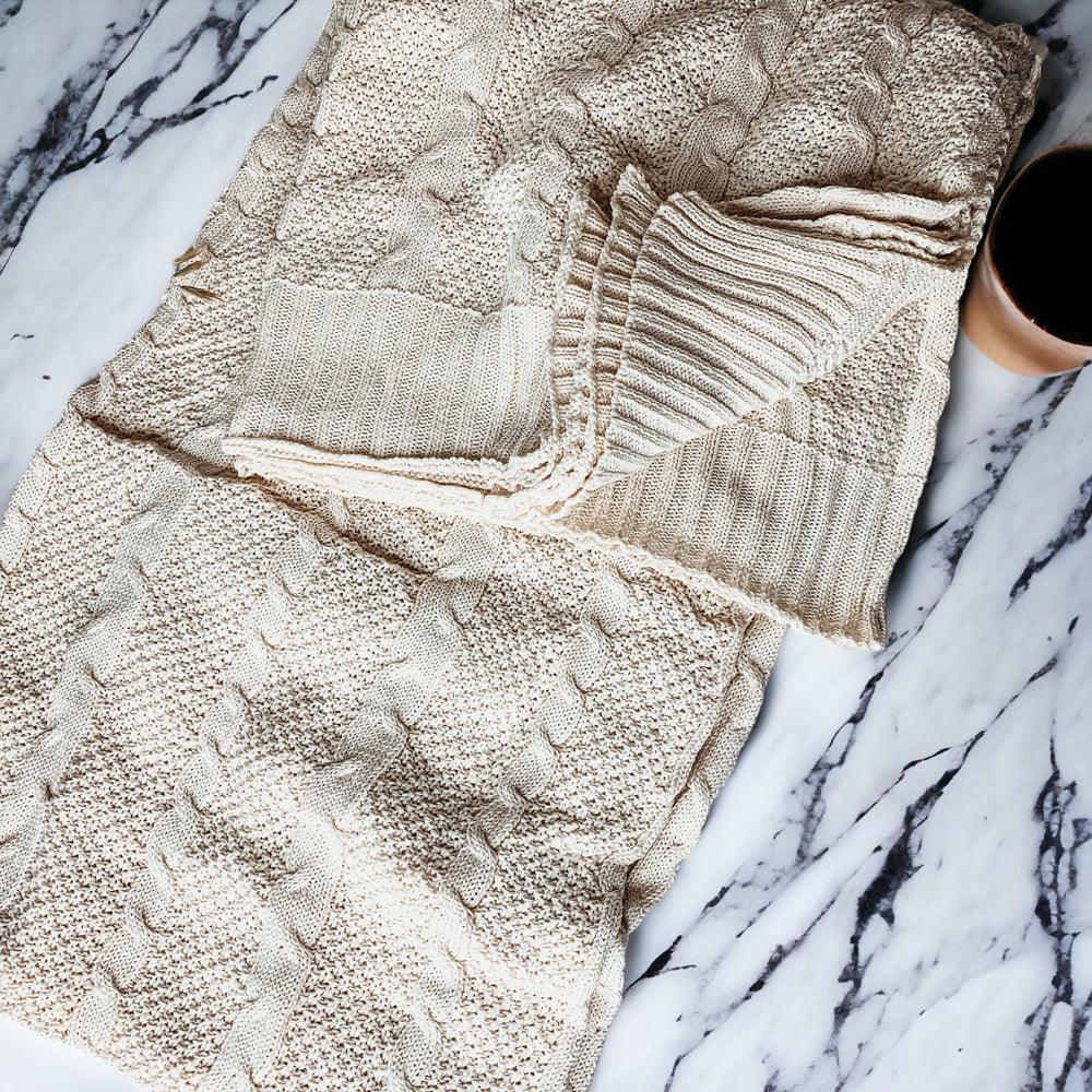 Claret Cotton-Blend Cable-Knit Throw: Close-up of cream cable-knit panels and fringed edge.