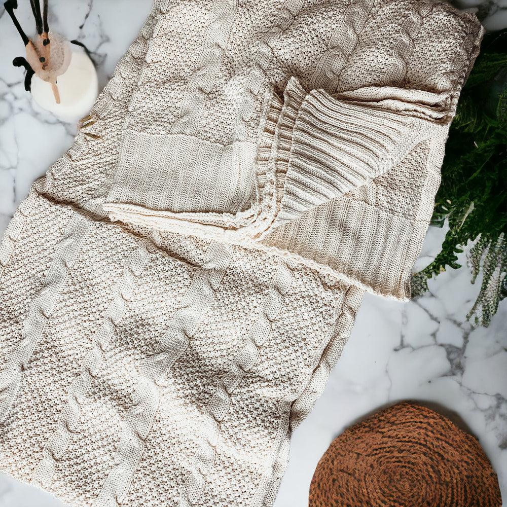 Claret Cotton-Blend Cable-Knit Throw: Cream cable-knit throw beside a mug and a small pumpkin.