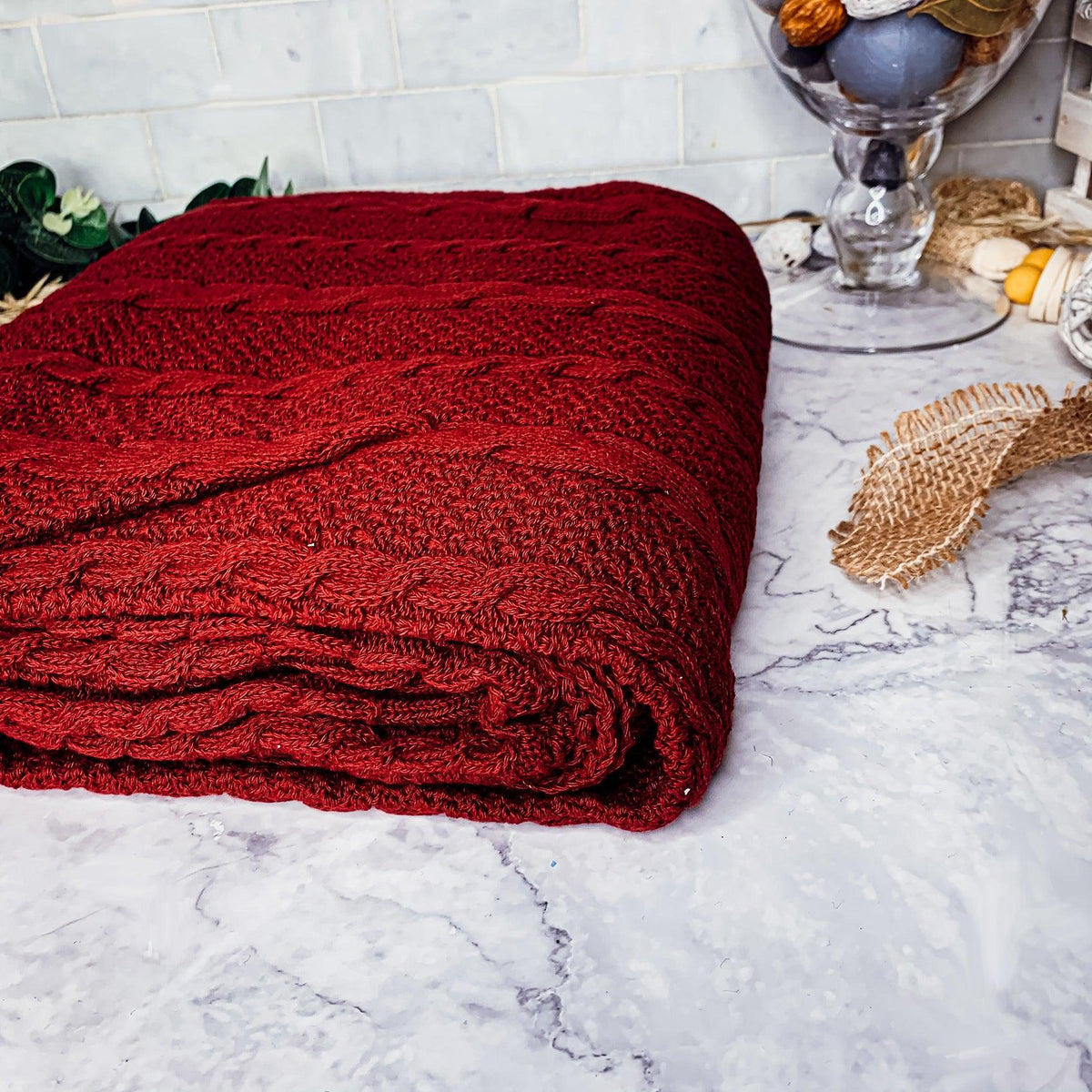 Claret Cotton-Blend Cable-Knit Throw: Folded red cable-knit throw on a light surface.