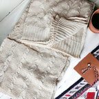 Claret Cotton-Blend Cable-Knit Throw: Cream cable-knit throw folded on a styled surface.