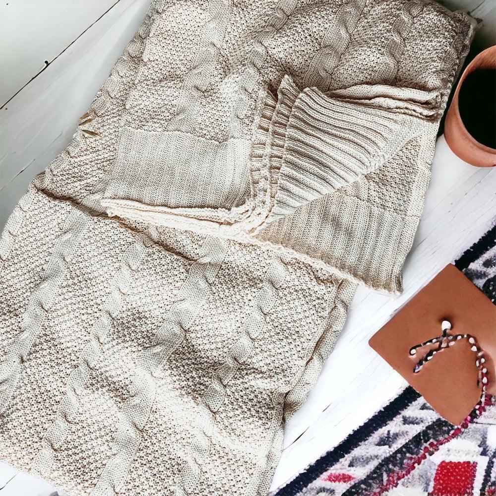Claret Cotton-Blend Cable-Knit Throw: Cream cable-knit throw folded on a styled surface.