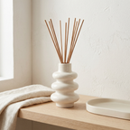 Stacked Bubble Gypsum Vase — White, 5 in: Bubble vase holding reeds on a bedside surface.