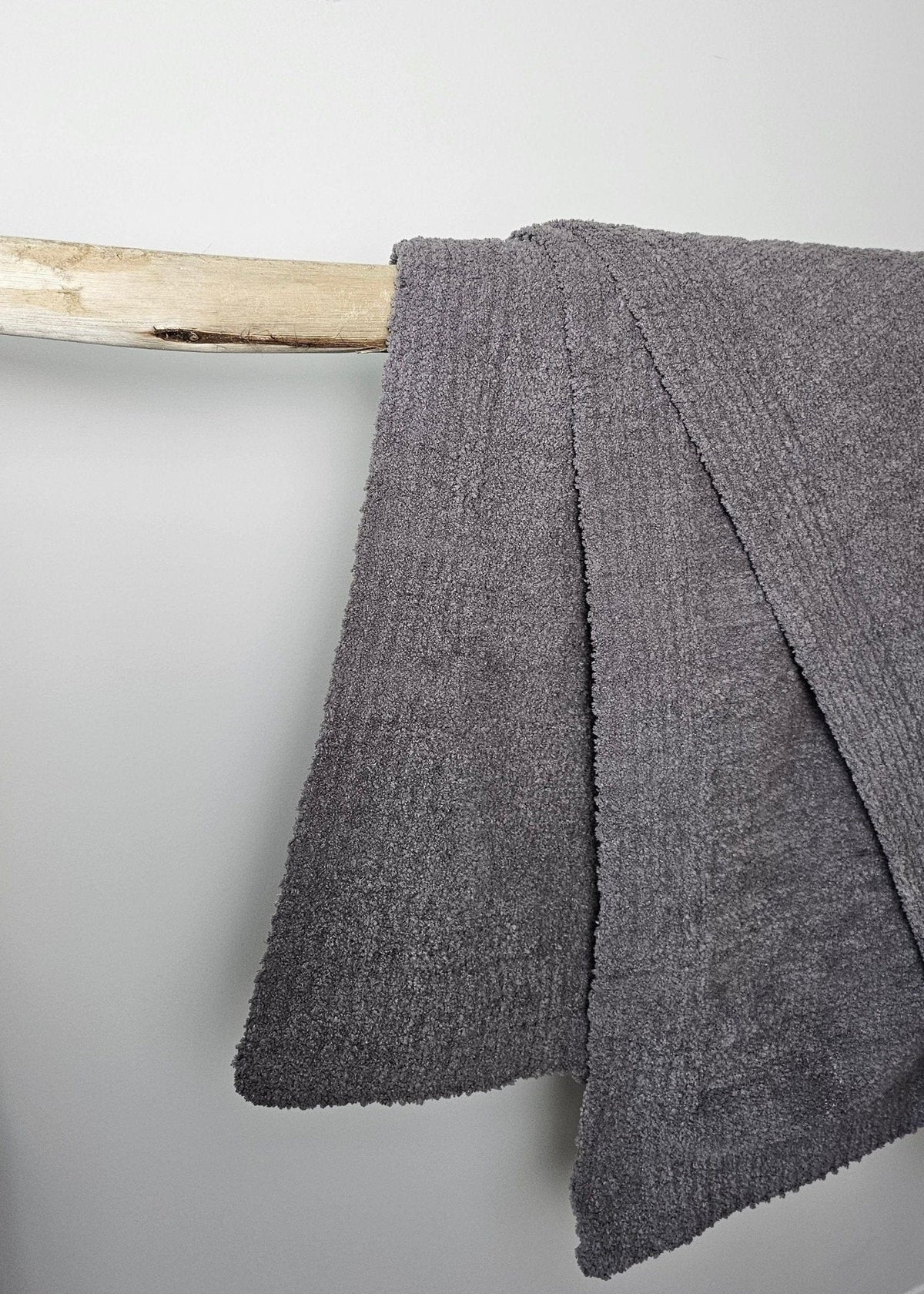 The Nest Microfiber Throw — 75 × 52 in: Close-up of the gray throw's stitched edge.